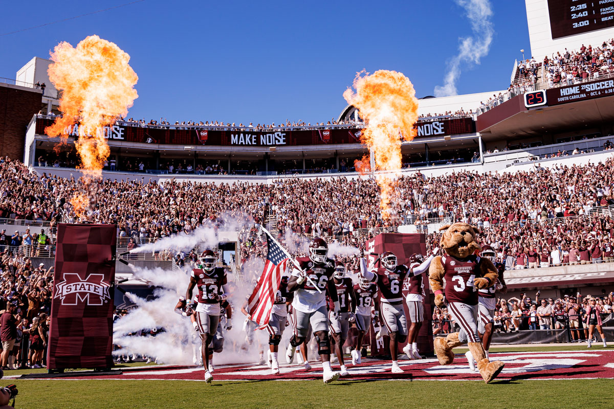 Picture of the football team running out the tunnel with Bully right before kick off in Davis Wade Stadium
