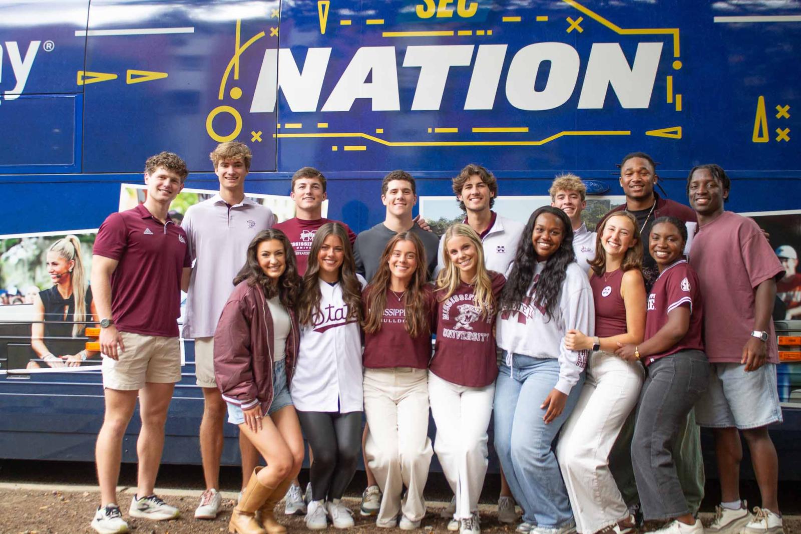 Group of diverse MSU students standing in front of the sec nation bus.