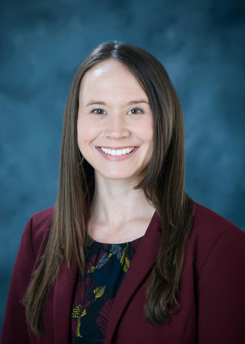 Portrait of Stacey Gotwald with long dark hair wearing a black shirt with a maroon blazer.