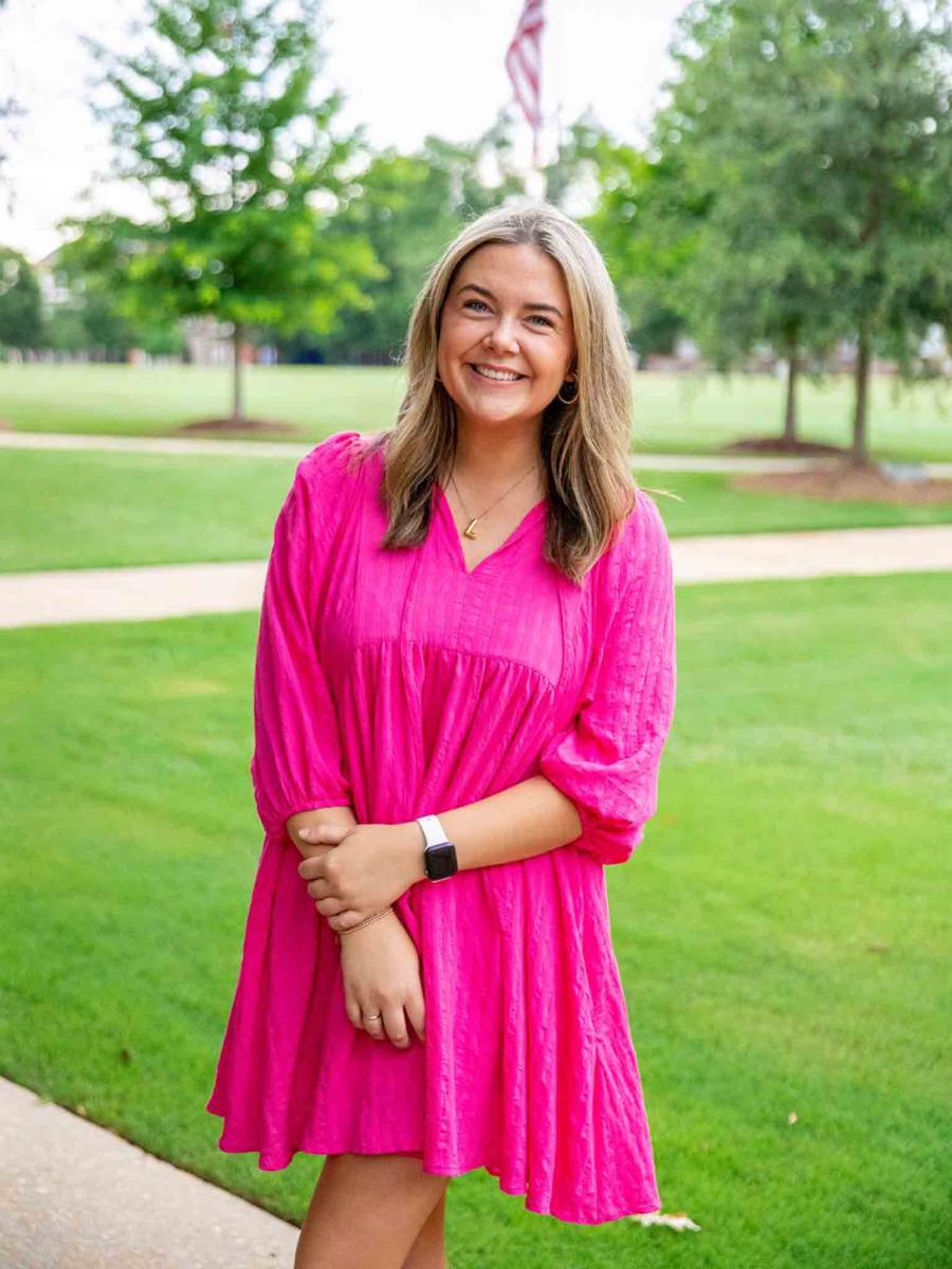 Mississippi State University professional headshot of a woman with blonde hair wearing a pink dress. 