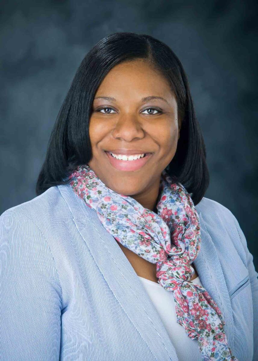 Mississippi State University professional headshot of a woman wearing a blue blazer and a floral scarf. 